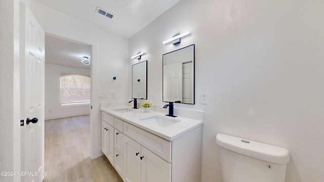 bathroom featuring vanity, hardwood / wood-style floors, and toilet