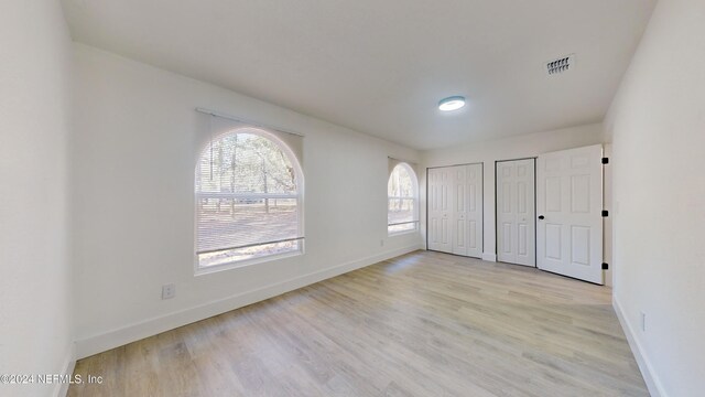 4774 Leopard Cir, Middleburg, FL 32068 - unfurnished bedroom featuring two closets and light wood-style floors
