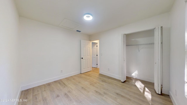 unfurnished bedroom with light hardwood / wood-style flooring and a closet