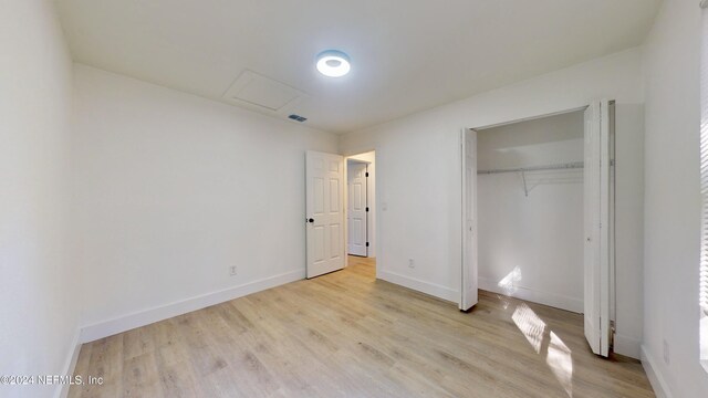 4774 Leopard Cir, Middleburg, FL 32068 - unfurnished bedroom with attic access, light wood-style floors, and a closet