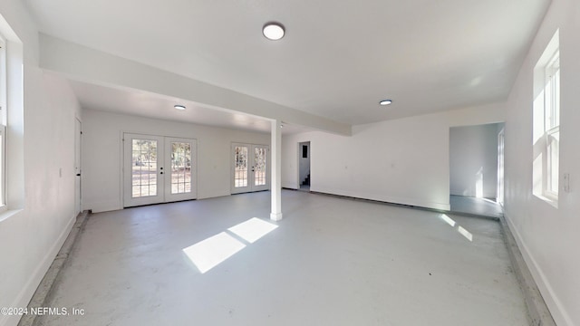 spare room featuring concrete floors and french doors