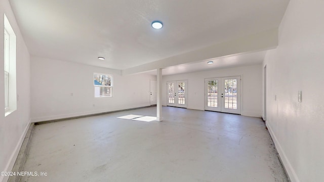 spare room featuring concrete floors and french doors