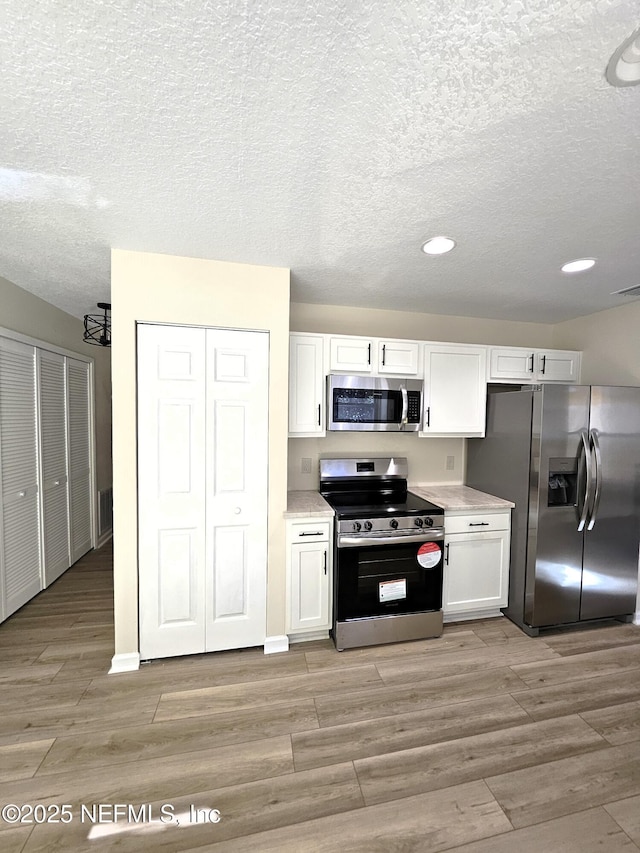 kitchen with white cabinetry and appliances with stainless steel finishes