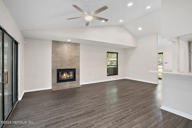 unfurnished living room with a tile fireplace, high vaulted ceiling, dark hardwood / wood-style floors, and ceiling fan