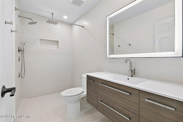 bathroom featuring tile walls, tile patterned flooring, vanity, toilet, and walk in shower