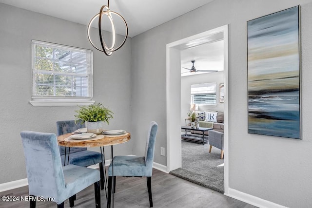 dining room with ceiling fan with notable chandelier and hardwood / wood-style flooring