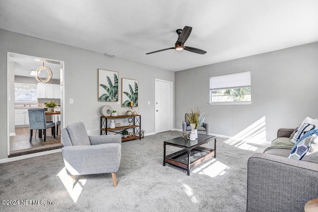 carpeted living room with ceiling fan