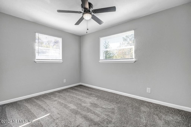 empty room with ceiling fan, a healthy amount of sunlight, and carpet floors