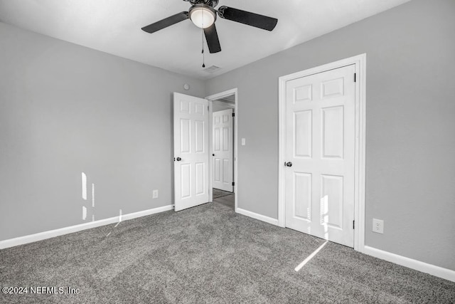 unfurnished bedroom with ceiling fan and dark carpet