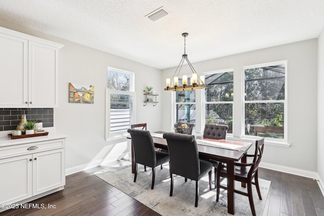 dining area featuring plenty of natural light, dark hardwood / wood-style floors, and a textured ceiling