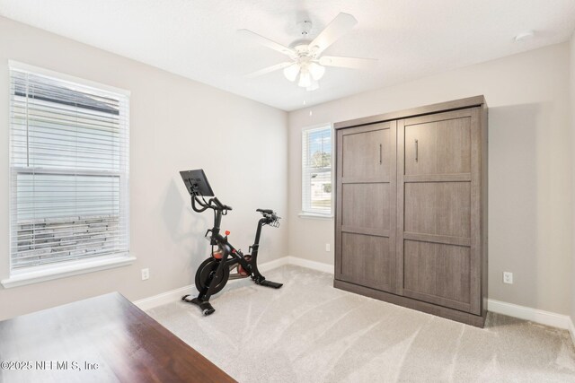 exercise room featuring ceiling fan and light colored carpet