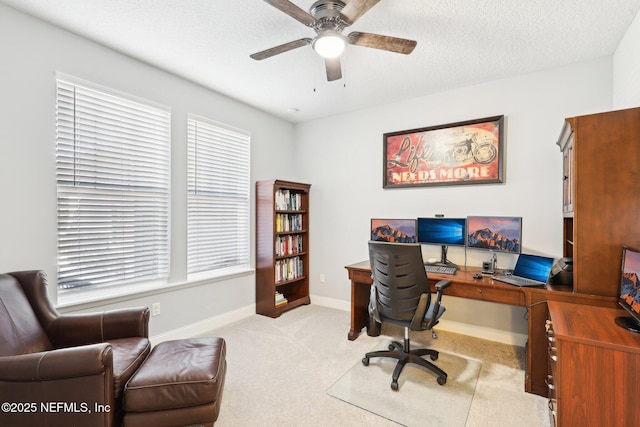 home office featuring ceiling fan, a textured ceiling, and light carpet