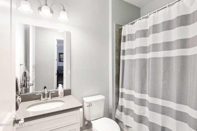 bathroom featuring toilet, a textured ceiling, walk in shower, and vanity