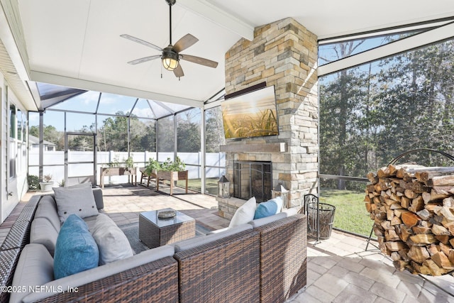 view of patio / terrace with ceiling fan and an outdoor living space with a fireplace