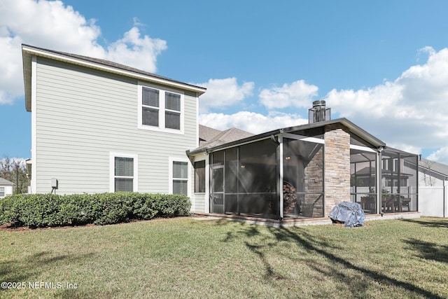 rear view of house with a sunroom and a yard