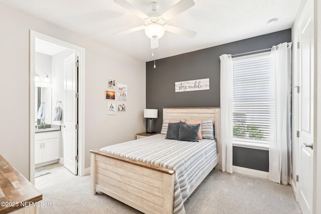 carpeted bedroom with ceiling fan and ensuite bathroom