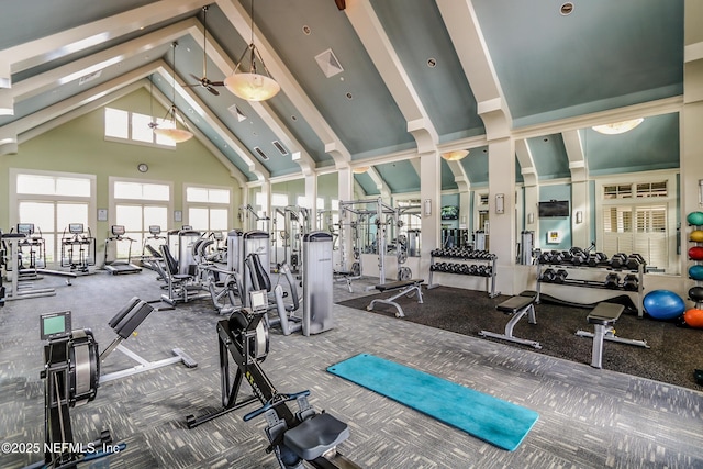 gym featuring high vaulted ceiling, carpet, and decorative columns