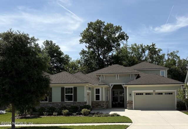 1637 Orange Branch Trl, Saint Johns, FL 32259 - view of front facade featuring a garage, stone siding, driveway, a front yard, and french doors