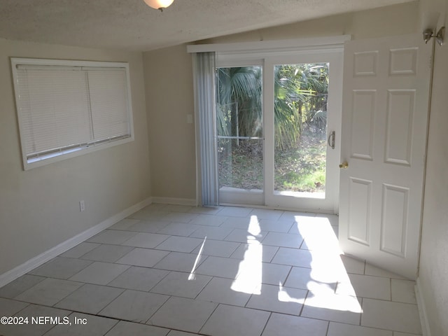 interior space featuring light tile patterned floors and a textured ceiling