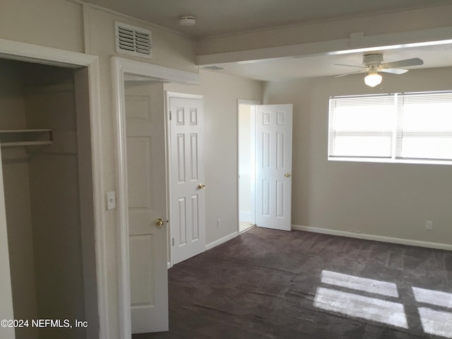 unfurnished bedroom featuring dark carpet and ceiling fan