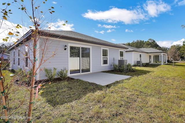 rear view of house featuring a yard, a patio, and central AC unit