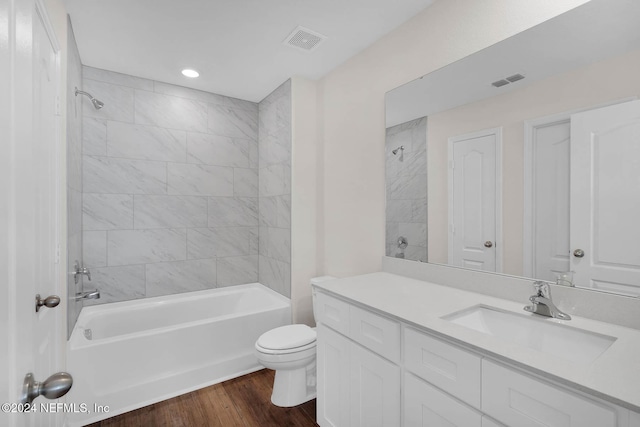 full bathroom featuring wood-type flooring, vanity, toilet, and tiled shower / bath