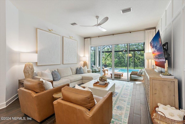 living room featuring a textured ceiling, dark hardwood / wood-style floors, and ceiling fan