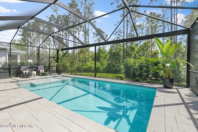 view of pool with a patio area and glass enclosure