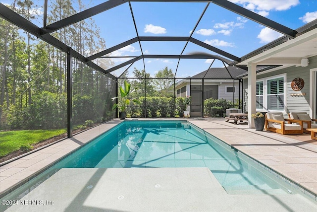 view of swimming pool featuring a patio and glass enclosure