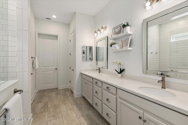 bathroom featuring walk in shower and vanity