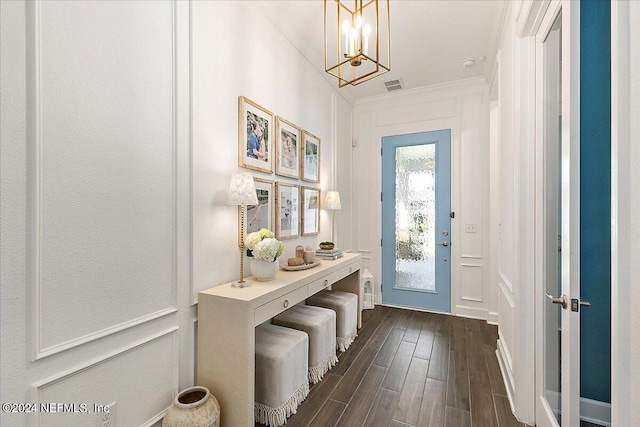 doorway featuring crown molding, a chandelier, and dark hardwood / wood-style flooring