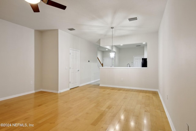 unfurnished living room featuring ceiling fan and hardwood / wood-style floors