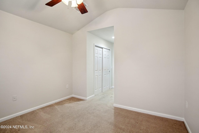 empty room featuring light carpet, ceiling fan, and lofted ceiling