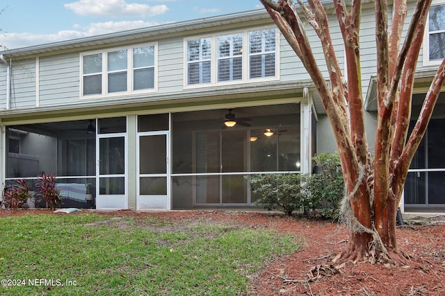 rear view of house featuring a lawn, a sunroom, and ceiling fan