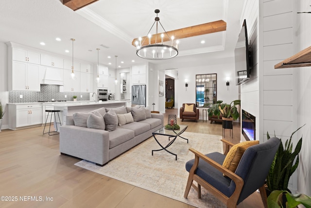 living area featuring light wood-type flooring, a notable chandelier, and recessed lighting