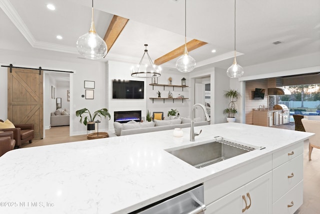 kitchen with a barn door, recessed lighting, open floor plan, and a sink
