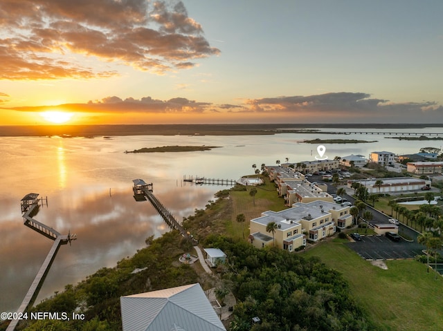 aerial view at dusk featuring a water view