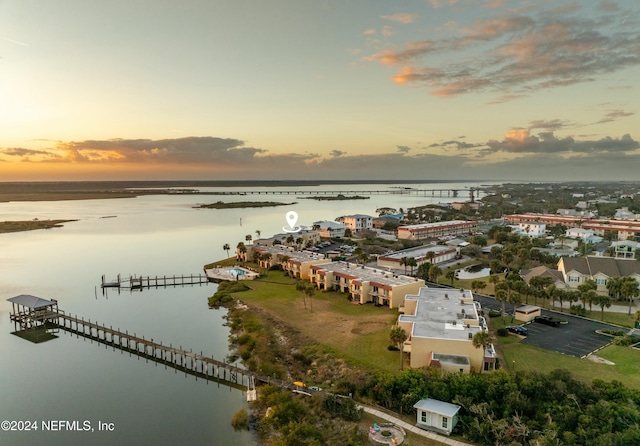 aerial view at dusk featuring a water view