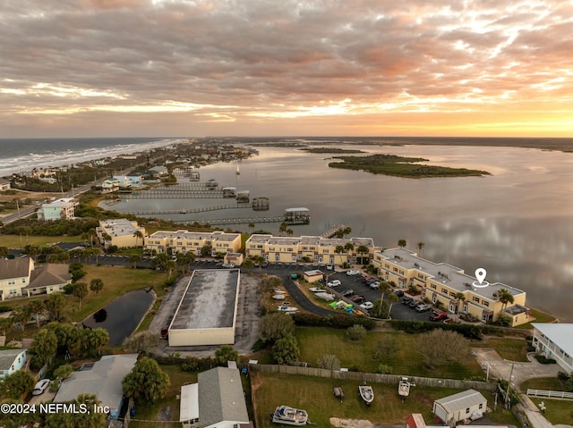 aerial view at dusk featuring a water view