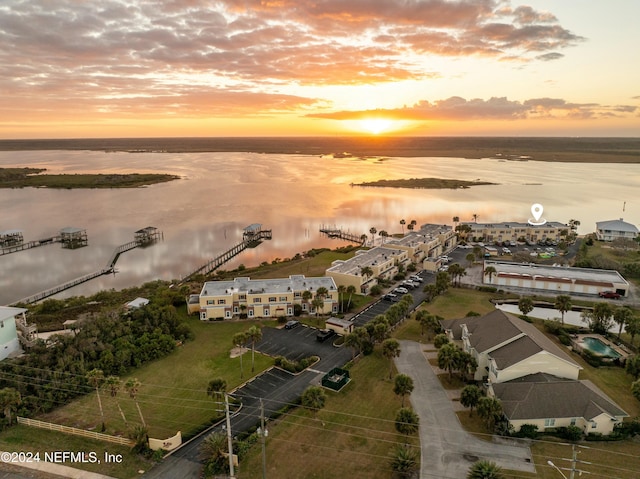 aerial view at dusk featuring a water view