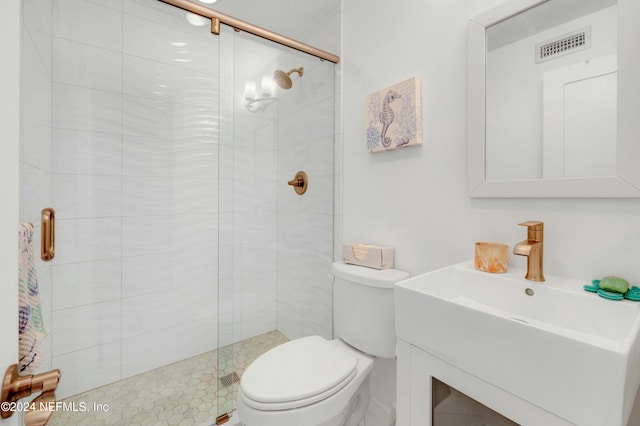 bathroom with vanity, toilet, and a shower with shower door