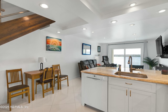 kitchen featuring sink, light tile patterned floors, white cabinetry, white dishwasher, and light stone counters