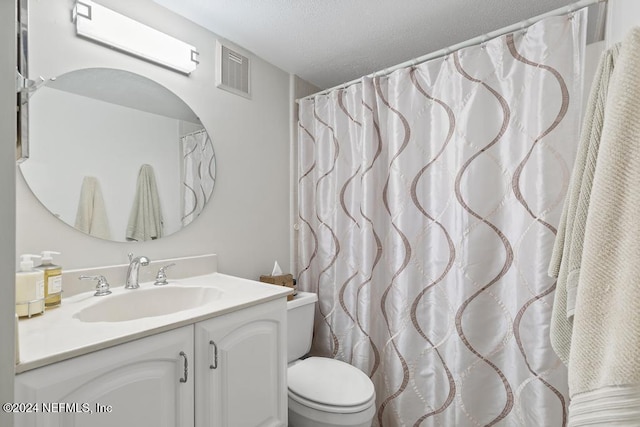 bathroom featuring vanity, toilet, and a textured ceiling