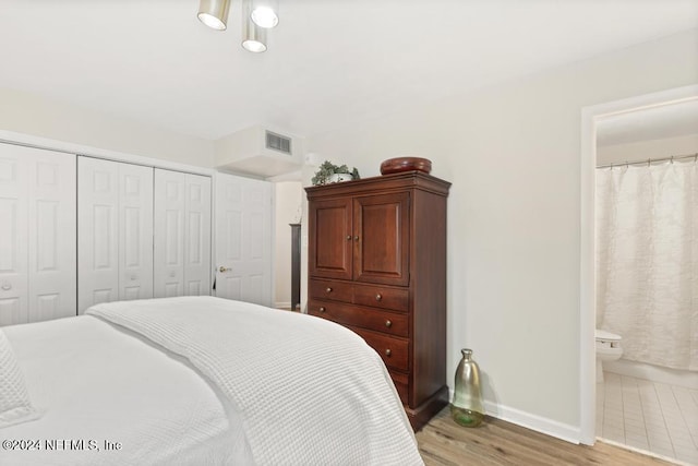 bedroom featuring ensuite bathroom, light hardwood / wood-style floors, and a closet