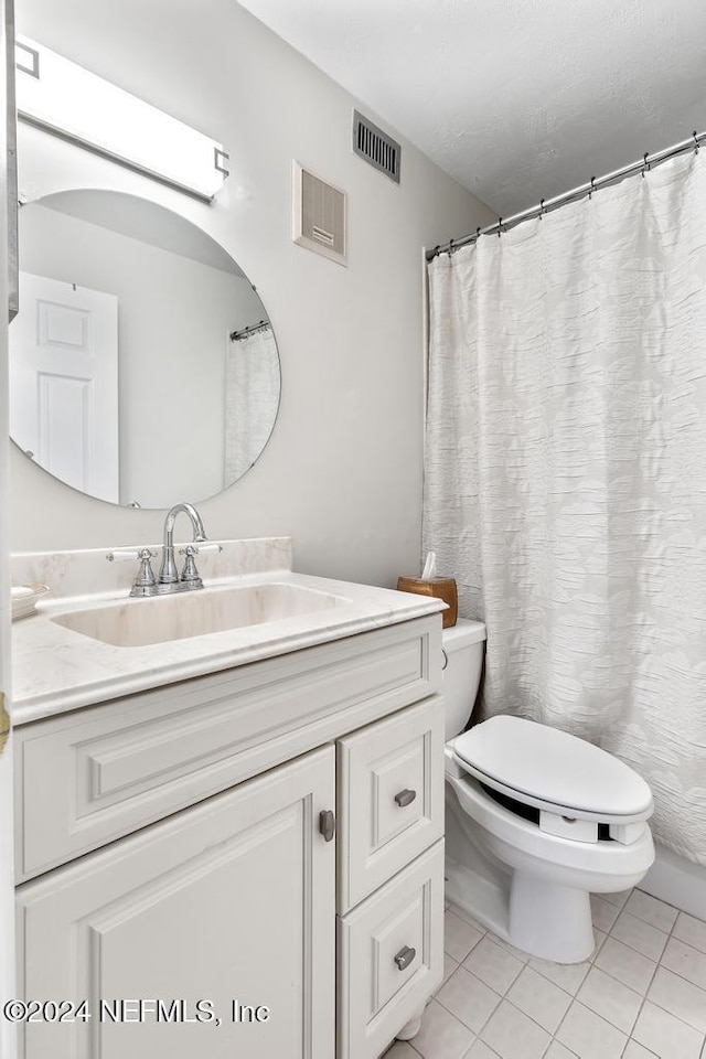 bathroom with tile patterned flooring, vanity, and toilet