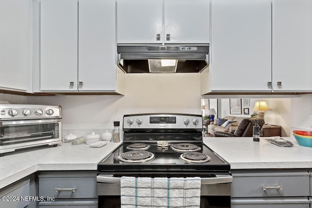 kitchen featuring white cabinets, stainless steel range with electric cooktop, and gray cabinetry