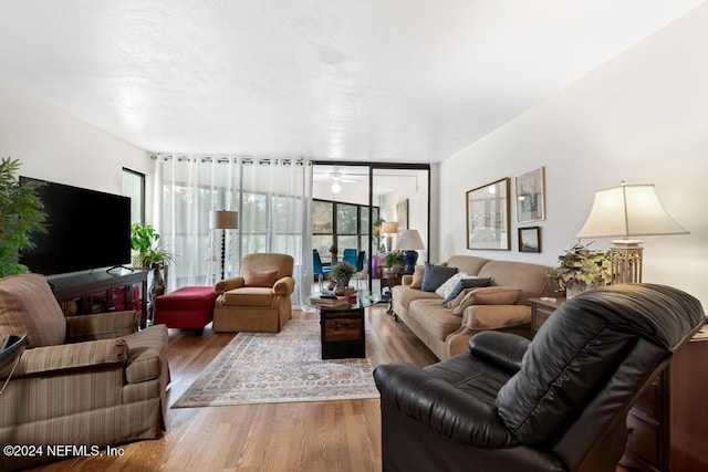 living room featuring floor to ceiling windows, ceiling fan, and hardwood / wood-style flooring