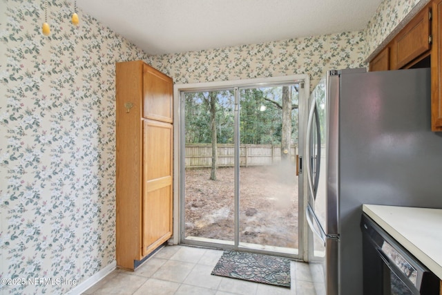 kitchen featuring dishwasher, stainless steel refrigerator, and light tile patterned floors