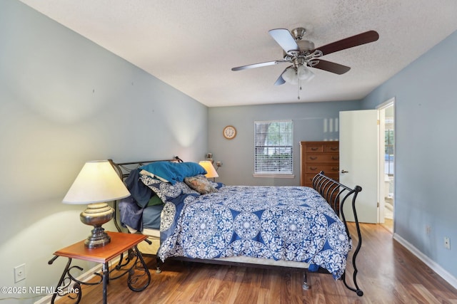 bedroom with wood-type flooring, a textured ceiling, and ceiling fan