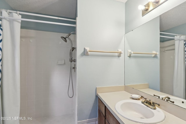 bathroom with a textured ceiling, vanity, and curtained shower